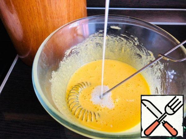 Heat the milk to 60 g. and add a thin stream to the yolk mass.