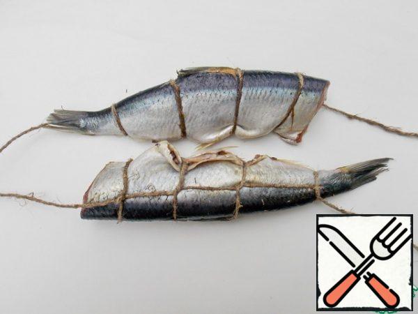 To keep the herring in shape and make it easier to remove, tie it with twine. It should be natural so that it does not pop up during cooking. Or without it at all.