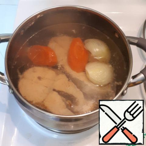 Pour about 1 liter of water into a saucepan, bring to a boil, put the carrots and onions in boiling water, and cook for 10 minutes. Then put the fish, add salt and pepper to taste and cook for another 15 minutes.