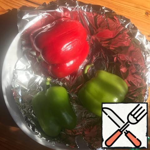 First of all, we need to bake peppers in the oven. I put the form with them at 200 degrees for half an hour, until the skin darkens. After the oven, put the peppers in a container, close and leave for 10 minutes — so the skin better departs.