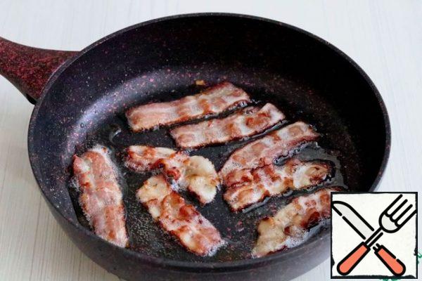 Fry the bacon strips on both sides until lightly browned on a low heat. Then drain the excess fat, leaving only the necessary amount for roasting / stewing the liver. In the future, you can fry potatoes on the melted fat or prepare a fry for soup.