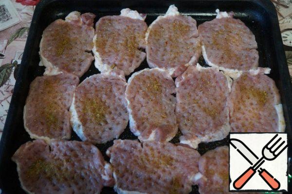 Chop off the meat pieces and put them on a greased baking sheet. Salt the meat to taste and season with spices and allspice.