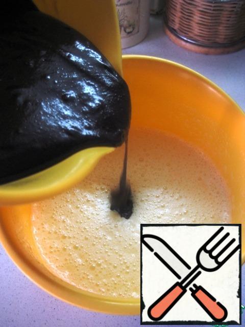 Pour the chocolate-flour mixture into the egg mixture, stirring thoroughly with a spatula. The dough turns out to be liquid, drains from the spatula.