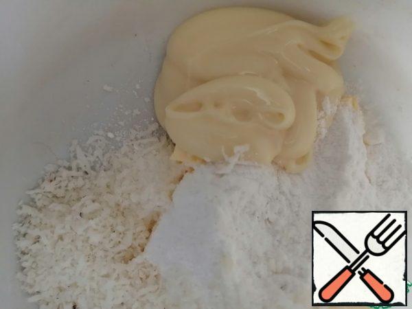 Preparing the cream filling. In the bowl for the mixer, we send softened butter, condensed milk, powdered sugar and coconut shavings (I used shavings made by myself from coconut and then dried).