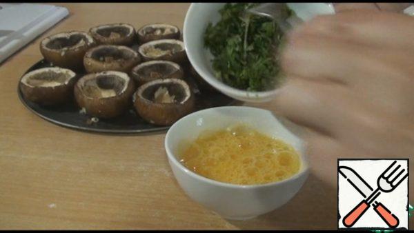 In the same bowl, break the eggs, add a little salt, add a small chopped bunch of any herbs, stir.