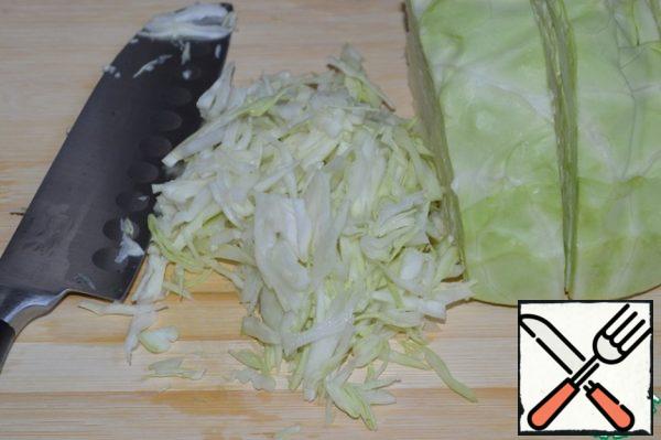 Chop the cabbage into strips and put it in a salad bowl.