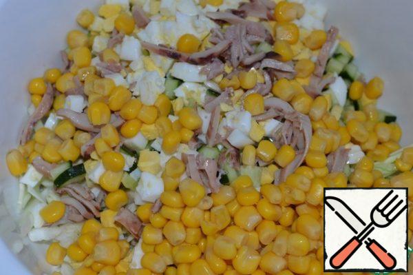 Add corn and squid, cut into strips, to the salad bowl.