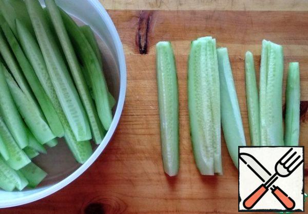 Cut each cucumber into 8 strips.