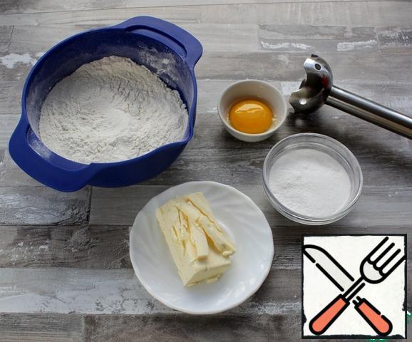 Cut the well-cooled butter into pieces, put it in the bowl of a blender, add flour, powdered sugar, and add the yolk.