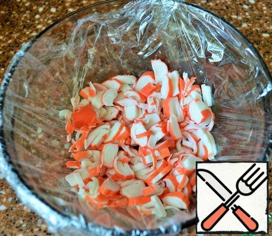 Salad bowl, 1.5 l., cover with plastic wrap.
140 g. chop sticks, put in a salad bowl, grease 1 tsp mayonnaise.