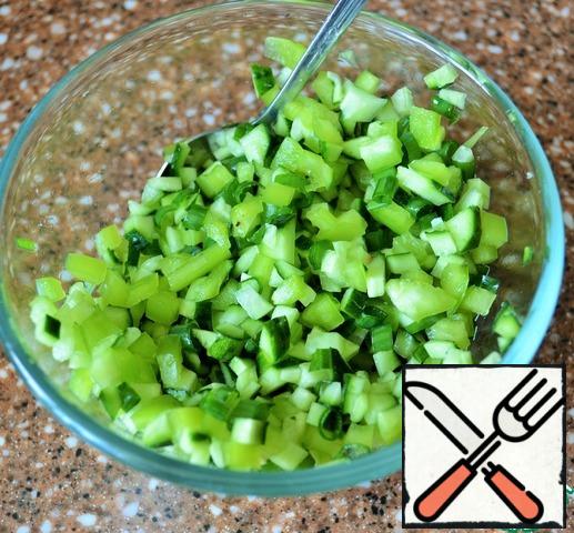 Wash the cucumber and pepper, cut into small cubes, add the chopped herbs, salt and mix.