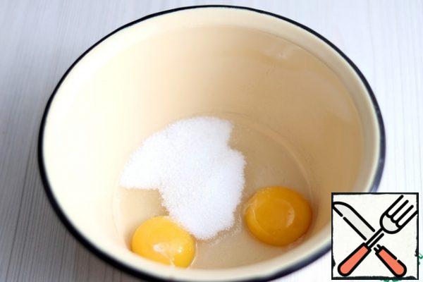In a bowl, add 2 egg yolks, add 2 tablespoons of sugar. Beat the mixture until white.