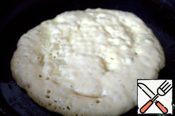 Grease a heated frying pan and pour a few spoonfuls of dough into the center.