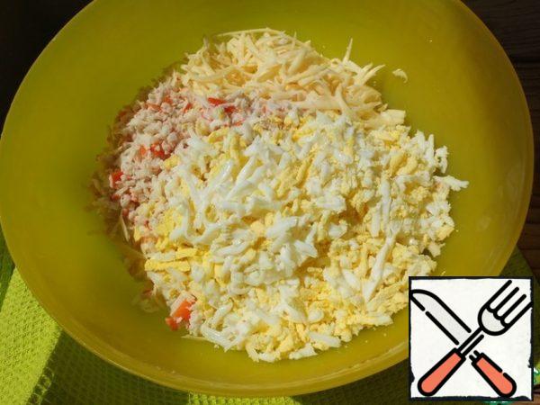 From the specified number of ingredients, two large rolls are obtained.
Three grated cheese, eggs and crab sticks.