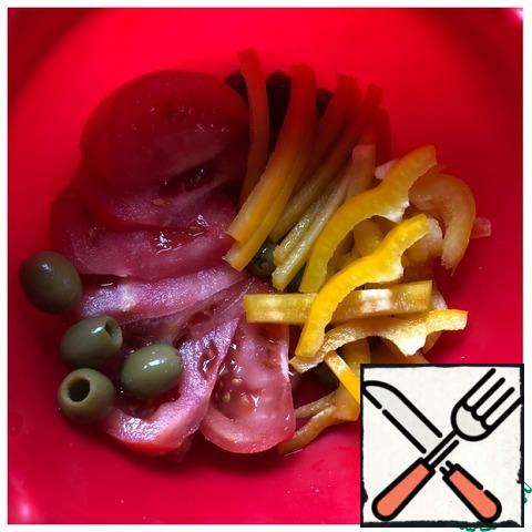 In a salad bowl, put the olives, cut the tomato into thin slices, and pepper into straws.