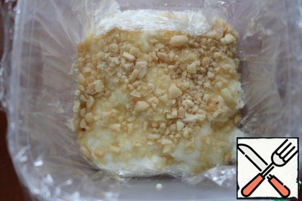 Cover the form with plastic wrap and pour out some of the peanuts. Pour out the milk mixture and top with the remaining peanuts. Put in the refrigerator for a few hours, or better at night.