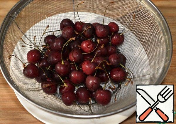 We take cherries with tails, so more effectively. Put them in a colander and wash them thoroughly. Let it drain.