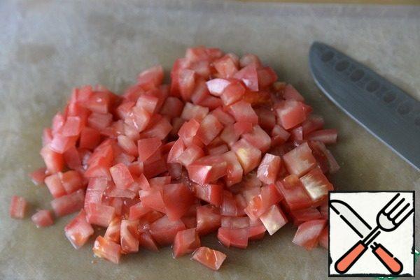 Cut the tomatoes into cubes and throw them on a sieve to drain the excess liquid.