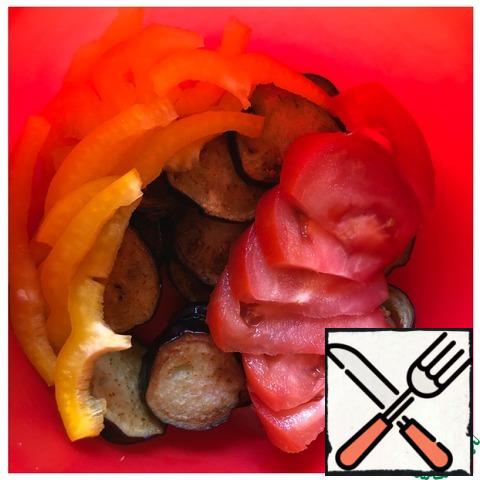 In a salad bowl, put the eggplant, tomatoes cut into slices and chop the pepper into strips.