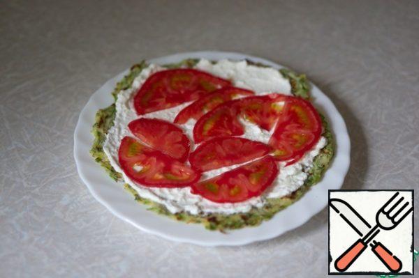 Assemble the cake by layering the pancakes with cheese cream and tomato slices.
