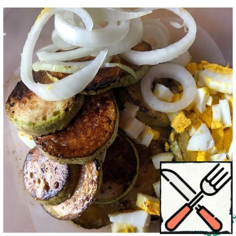 In a salad bowl, put the onion cut into thin rings and the eggs cut into a medium cube. Add the cooled zucchini.