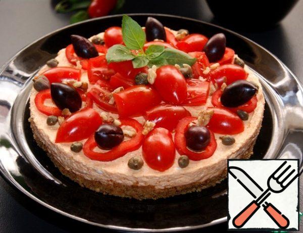 Release the cheesecake from the mold and garnish with rings of pepper, cherry, capers, olives and a sprig of Basil. Sprinkle with nuts.