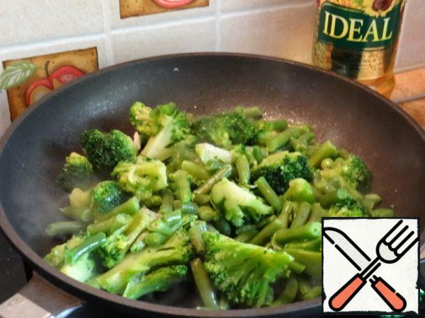 Lightly fry the broccoli, beans and chopped garlic in a preheated frying pan in oil;