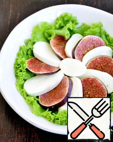 Disassemble the salad, put it on the bottom of the plate, put the sliced figs and mozzarella on the salad.
