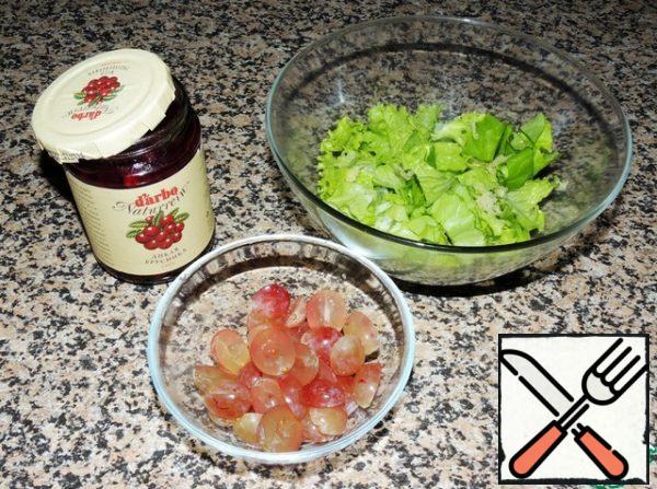 Cut the grapes into halves and remove the seeds (if any). Cut the salad coarsely or tear it with your hands, leave a few leaves for serving. Add the crushed garlic clove and lingonberry sauce, which will give a unique sweet and tart taste.
