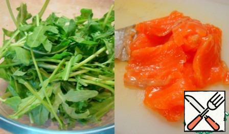 Wash the arugula, dry it and pick it in a large bowl with your hands. Cut the fish into thin plates.