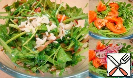 Mix the arugula, fresh and dried tomatoes, onions, fish and rice. Pour in the dressing, mix, put on a dish and sprinkle with feta cubes on top.