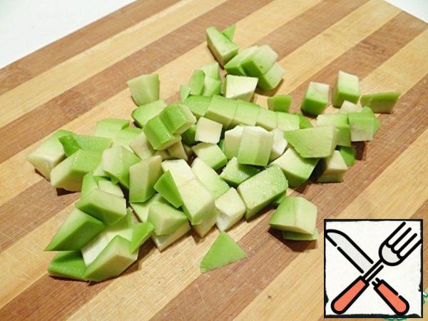 Bring the water to a boil, put the rice in bags and cook on low heat for 15 minutes. I wash the avocado, peel it, and cut it into cubes.