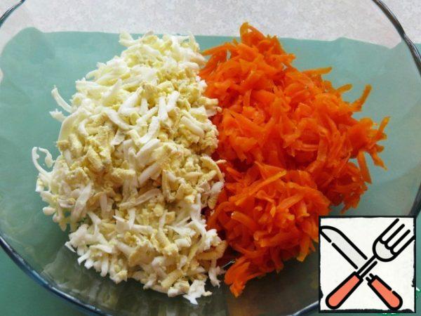 Eggs and carrots three on a large grater.
