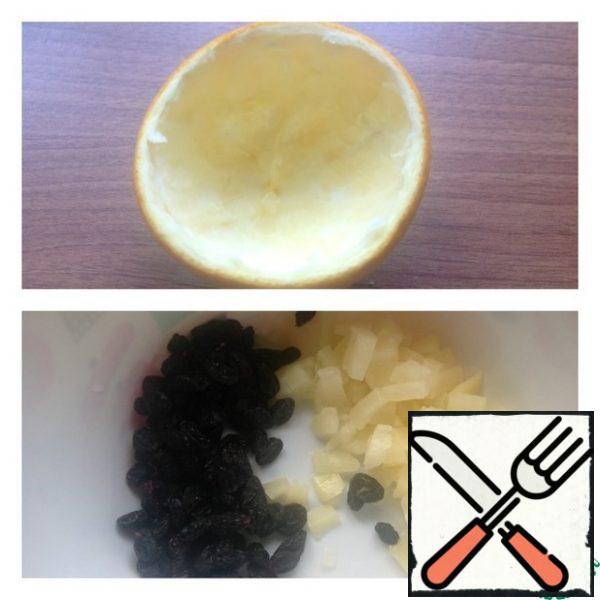 Wash the orange and dry it. cut in half, and carefully first with a knife and then with a spoon pull out the pulp.
In a salad bowl, put finely chopped pineapple and raisins squeezed from excess liquid.