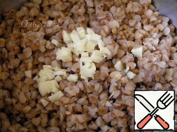 Boil water for buckwheat, lower the bag and cook until ready. Meanwhile, cut the olives into circles, dice the pepper and finely chop the garlic. As soon as the buckwheat is cooked, carefully open the bag and put the grits in a suitable container. Add the garlic and stir.
