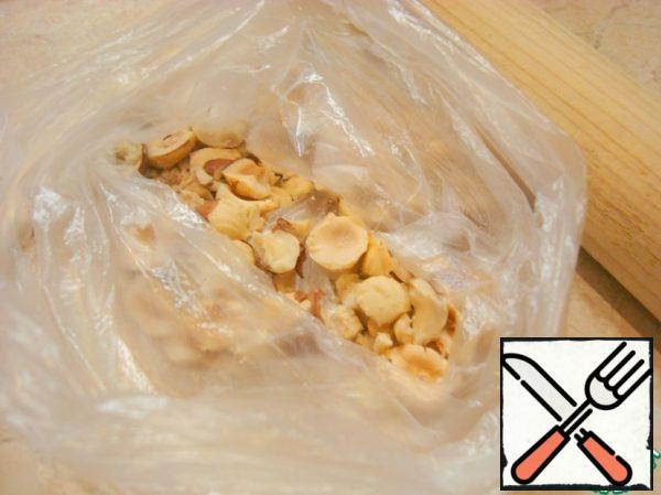 Put the nuts in a bag and walk over the top with a rolling pin, so that they break up into large pieces.