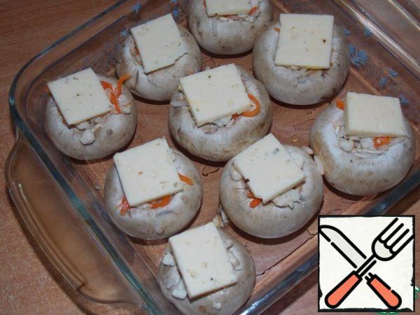 Cut the cheese into small slices.
Spread on the mushrooms.
Bake in a preheated oven at 180 C for 20-25 minutes.