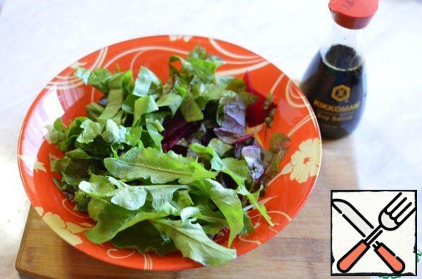 In a bowl, combine the beets and greens.
Season with olive oil and soy sauce.