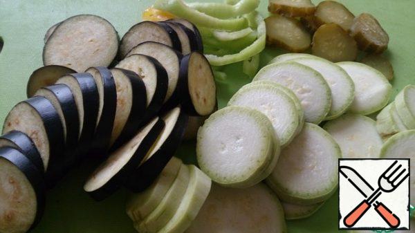 Wash all vegetables. Zucchini, eggplant and cucumber cut into circles, onion and bell pepper half-rings, tomato cut into slices.