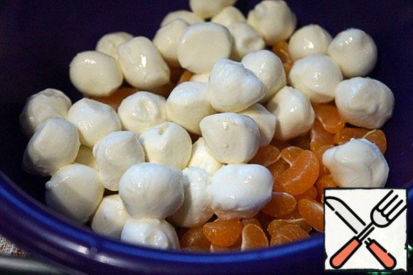 From the cheese, drain the brine, put the balls whole to the tangerines.