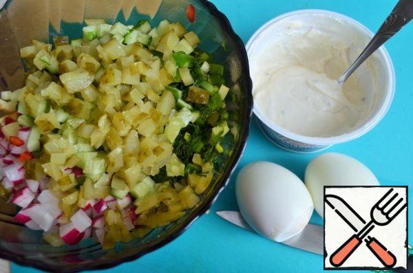 Cut the fresh cucumber into small pieces and lay it out.
Add the marinated.
Eggs clean, a 1.5 PC cut in the salad.