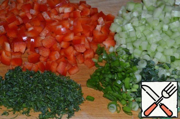 Cut the pepper into small cubes.
Peel the cucumbers and cut them into small cubes.
Chop the greens.