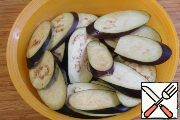 Cut the eggplants into circles, sprinkle with salt -so when frying, the eggplants will absorb less oil - and leave for 30 minutes.