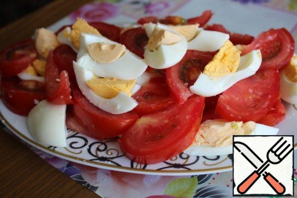 Cut large slices of tomatoes and boiled eggs. We put everything in a dish, sprinkle each layer.