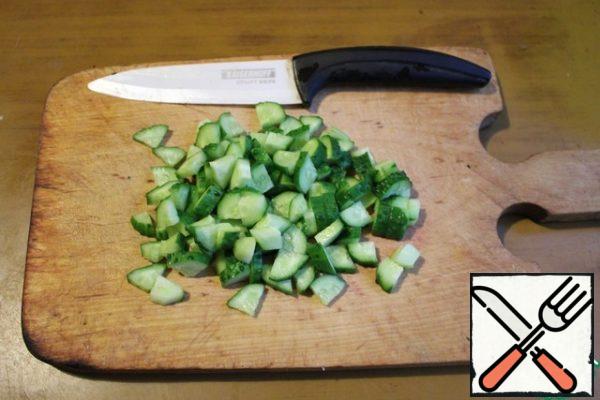 Wash the cucumbers, dry them, and cut them into cubes.