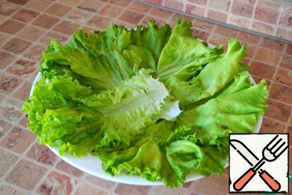 Put the salad leaves on a plate.