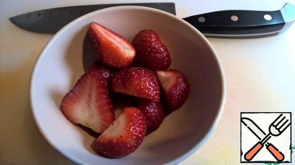 Peel the strawberries from the stalks and cut them in half.