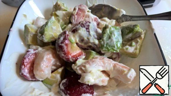 Put all the ingredients in an auxiliary bowl (leaving a couple of strawberry slices and a couple of prawns for decoration), fill with yogurt with zest and mix.