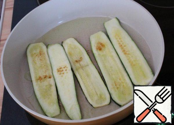 Wash the zucchini and cut them lengthwise into plates about 5 mm thick. Add salt and leave for 10 minutes.
Heat the vegetable oil in a frying pan and fry the cut zucchini on both sides.
Place on a plate with a paper towel to remove the fat. Leave to cool.