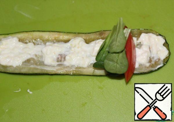 On the entire surface of the zucchini on one side, put the cheese and garlic mixture in a small layer. Then a slice of tomato on the wider edge of the zucchini. Next to the tomato is green.
Now carefully wrap the roll.